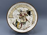 a decorative plate with a picture of a woman holding a sword