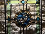 a stained glass window in the middle of a stone wall