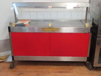 un comptoir rouge avec un plateau en métal et une armoire rouge