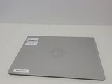 the laptop is sitting on a white surface with a sticker on it
