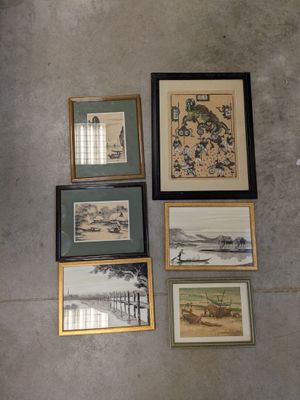 many framed pictures hanging on the wall of a room