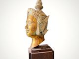 an image of a statue of a woman ' s head on top of a wooden block