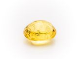 a yellow sapphire stone on a white background