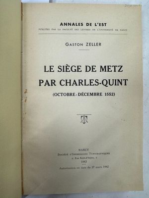 un livre ouvert posé sur une table à côté d'un mur blanc