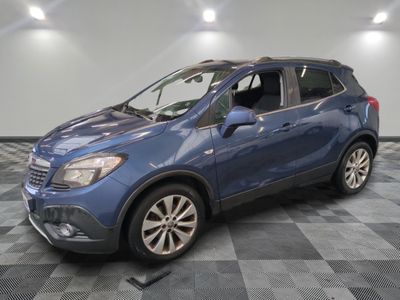 Le SUV Buick bleu est garé sur un sol en carrelage à damier.