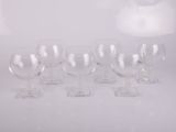 six verres à vin transparents posés sur une table blanche
