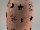 a clay jar with a star and moon design on it