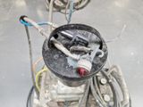 un seau noir sur lequel sont posés des outils, dans une pièce