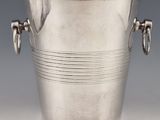 silver plated ice bucket with handles and handles on a grey background