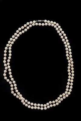 a single strand of pearl necklace on a black background