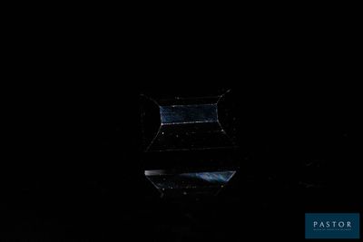 a glass vase sitting on top of a table in the dark