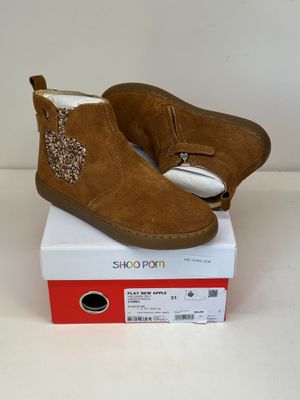 les chaussures sont posées sur la boîte, sur la surface blanche