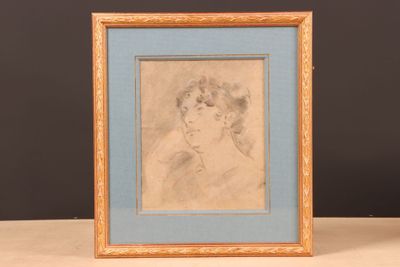 dessin d'une femme de profil, dans un cadre bleu, posé sur une table