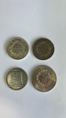 quatre pièces de monnaie britanniques différentes posées sur une surface blanche