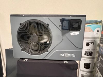 un climatiseur gris posé sur un boîtier noir
