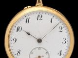 gros plan d'une montre de poche en or sur fond noir
