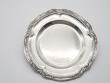 a silver plate on a table with a white background