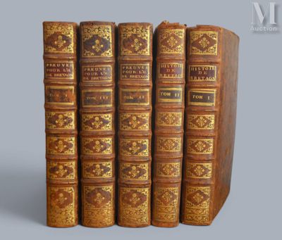 trois vieux livres sont empilés sur une table
