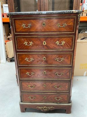 une commode ancienne avec un dessus en marbre et des poignées en laiton
