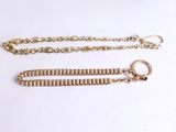 a close up of two gold chains on a white surface