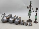 une statue représentant une femme debout à côté d'un groupe de canards