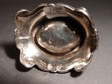 a silver plate that has a small silver object in it