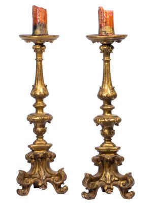 une paire de bougeoirs anciens en laiton, avec une bougie de chaque côté