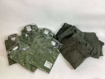 un tas de vêtements militaires posé sur une surface blanche