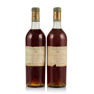 two bottles of wine sitting next to each other on a white surface