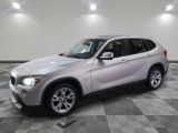 une photo d'un SUV BMW argenté garé dans un garage