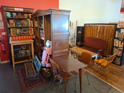 une pièce avec un canapé, une table, une chaise et une bibliothèque