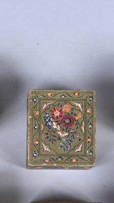 three small boxes with decorative designs on them sitting next to each other