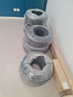many rolls of wires on the floor in a room