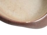 a close up of a brown bowl on a white surface