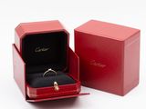 an open red box with a ring inside of it on a white surface