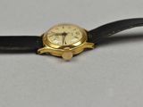 a watch that is sitting on a black leather strap
