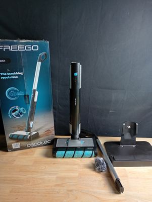 une boîte contenant un aspirateur et une serpillière, posée sur une table
