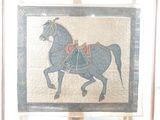 une photo d'un tableau représentant un cheval, exposé dans une vitrine