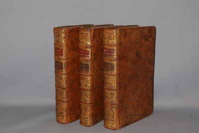two old books sitting on top of each other on a white surface