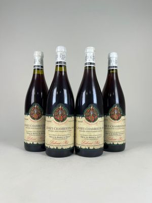quatre bouteilles de vin posées sur une table blanche
