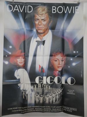 une vieille affiche de cinéma représentant David Bowie et une femme en smoking