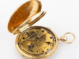 a close up of a pocket watch on a white surface