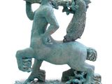 statue of a man riding a horse with a bag on his back