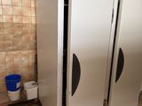 trois réfrigérateurs blancs dans une pièce aux murs carrelés