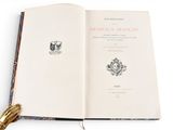 an open book with a tassel on top of it