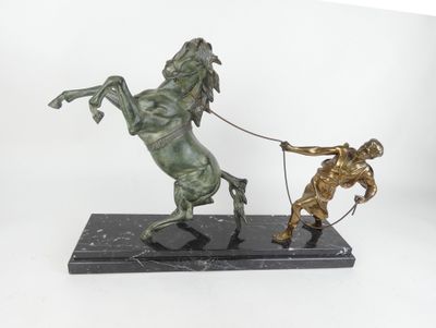 statue représentant un homme tirant un cheval à l'aide d'une corde, posée sur un socle en marbre