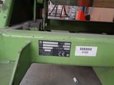 a green machine that is sitting in a warehouse