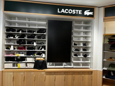 un grand présentoir de chaussures Lacoste dans un magasin