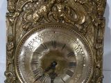 une horloge en or posée sur une surface blanche