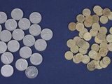two different types of coins are shown on a blue surface
